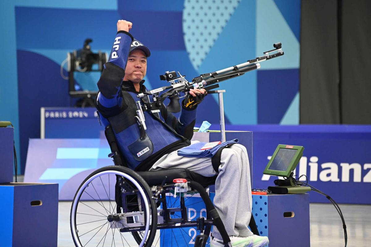 An athlete lifts his fist in air